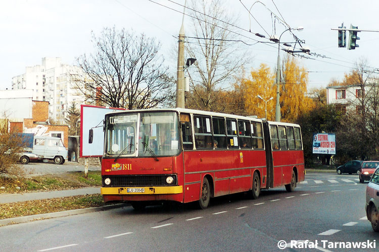 1811
Ikarus w kremowo-czerwonym malowaniu na linii 11 Grygowej - Lipniak mija rondo na Zana przy Leclercu i pawilonach na Wileńskiej. Nad autobusem widać zmodernizowaną niewiele wcześniej sieć trakcyjną. Nie było jeszcze wtedy sieci trolejbusowej na ul. Wileńskiej.
