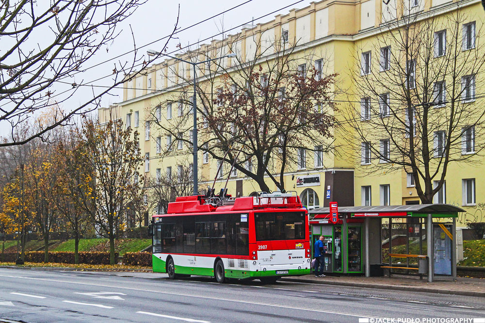 3907
Nowy Ursus uwieczniony w 2014 r. obok nowej wówczas wiaty przystankowej, będącej częścią projektu unijnego. W tle bloki osiedla ZOR Zachód, pochodzące z lat 50.

