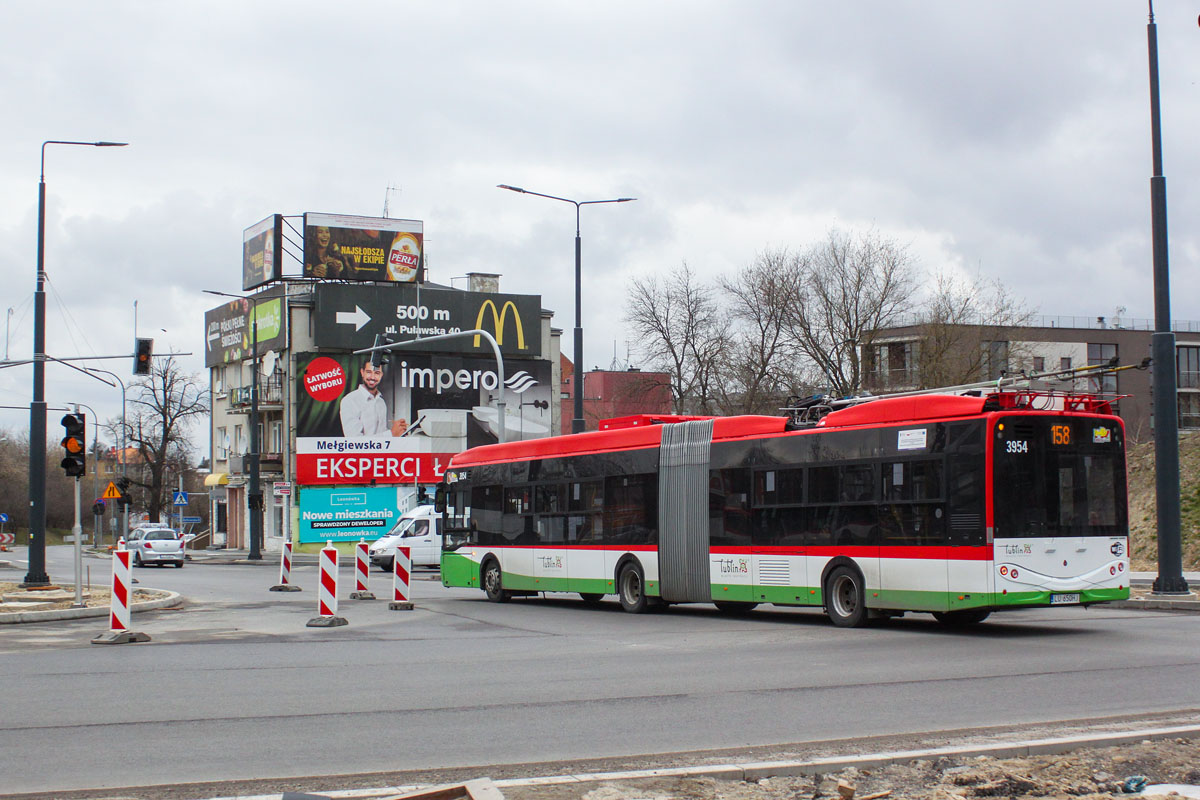 3954
Przebudowa Alej Racławickich w Lublinie zbliża się do końca. Nowe stalowe słupy, pomalowane na ciemnoszaro, z ledowymi lampami, są już ustawione. Zamontowano też częściowo wysięgniki, na których zawieszona będzie sieć. Trolejbusy jeżdżą tędy wciąż na bateriach lub agregacie. A w tle budynek porażony reklamozą.
