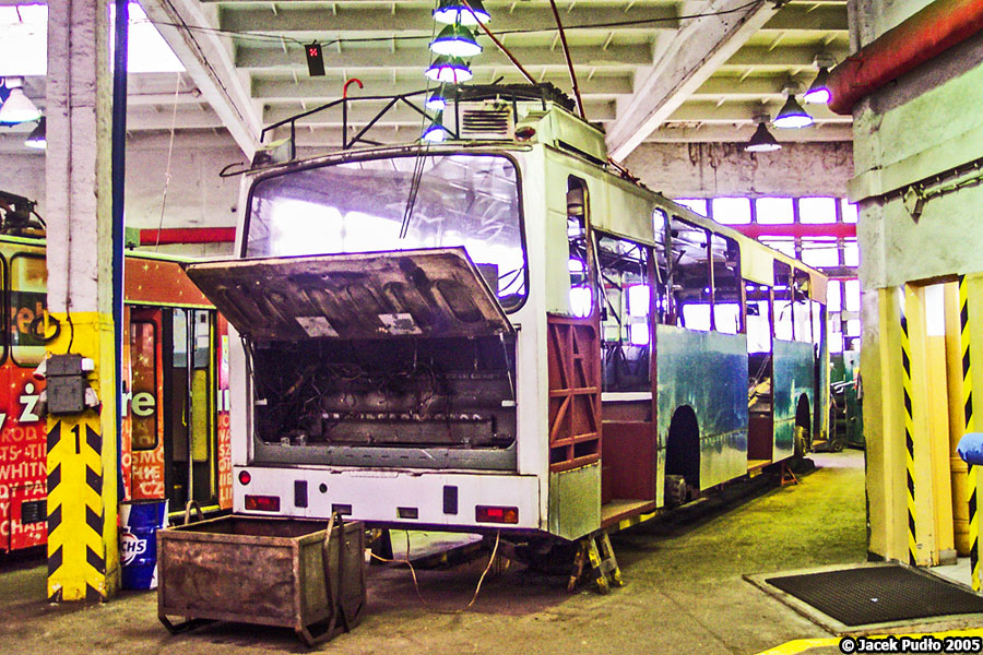 802
802 w długo trwającym remoncie. Naprawy główne lub średnie wykonywane w hali napraw bieżących były mniej kompleksowe, niż te z hali Berlieta. Pracownicy byli też z reguły zajęci codzienną obsługą trolejbusów i naprawami bieżącymi, stąd też remont trolejbusu mógł trwać i ponad rok, jak w tym wypadku. Jeśli chodzi o remont tego trolejbusu to jak widać nie demontowano szyby tylnej, podsufitki (co akurat było długi czas typowe), wymieniono lub naprawiono belki podwozia i ścian bocznych kratownicy, przyklejono ocynkowane blachy poszycia.
