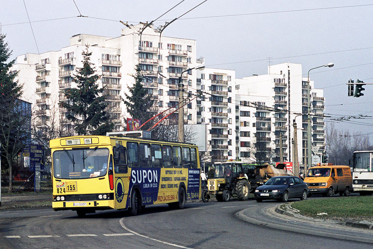 824
Dawny warszawski trolejbus przemierza wyremontowane w 2002 roku rondo. W tle architektura początku lat 90-tych XX wieku. 
